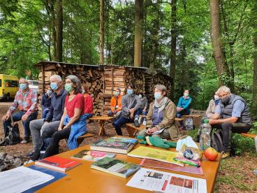 Eine Biologin erklärt den Freiwilligen am Tag der guten Tat, um welche Pflanzen es geht und weshalb diese ein Problem sind.